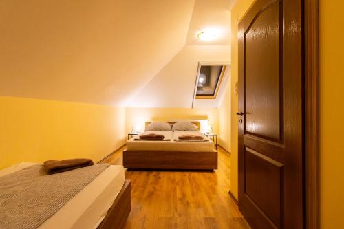 two beds in a small room with yellow walls at Szelidi Apartmanok in Dunapataj