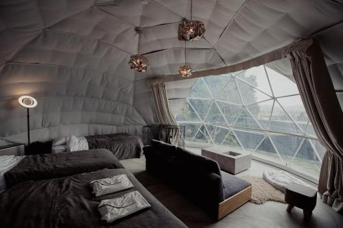 Zimmer mit 2 Betten und einem großen Fenster in der Unterkunft private your resort ITTEKURAi 松山 in Kawakami