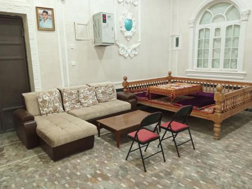 a living room with a couch and a table and chairs at Abubakir Guests House in Samarkand