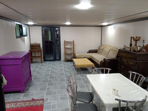 un soggiorno con un divano, un tavolo e delle sedie di Abubakir Guests House a Samarkand