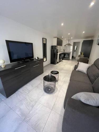 un salon avec un canapé et une télévision à écran plat dans l'établissement Grand Studio au Rdc dans résidence, clim, terrasse, à Martigues