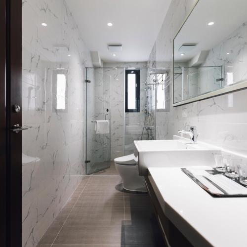 a bathroom with a sink and a toilet and a shower at 鹹菜巷8號 in Tainan