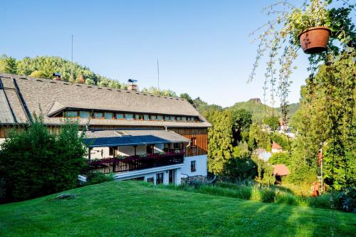 a house on a hill with a green yard at Penzion Na Výšinkách, Jetřichovice, České Švýcarsko in Jetřichovice