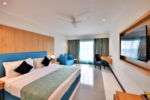 a bedroom with a large bed and a flat screen tv at The Fern Residency, Subhash Bridge, Ahmedabad in Ahmedabad