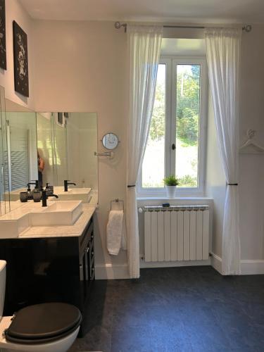 baño con lavabo y aseo y ventana en Chateau Laffargue, 