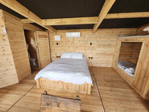 a bedroom with a bed in a wooden cabin at Biktot Ba Arafel in Nimrod
