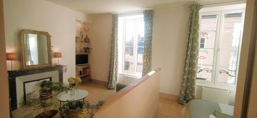 a living room with a fireplace and a mirror at Ô Bulles de Loire, Châteauneuf-sur-Loire in Châteauneuf-sur-Loire