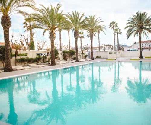 a swimming pool with palm trees in a resort at Kiko Park Oliva in Oliva