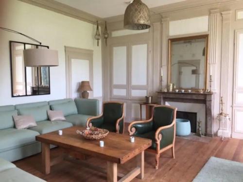 a living room with a couch and a table at Le Clos du bas hameau in Canouville