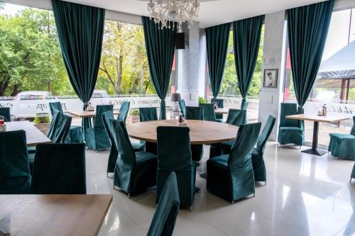uma sala de jantar com mesas e cadeiras verdes em Art Hotel Simona em Sófia