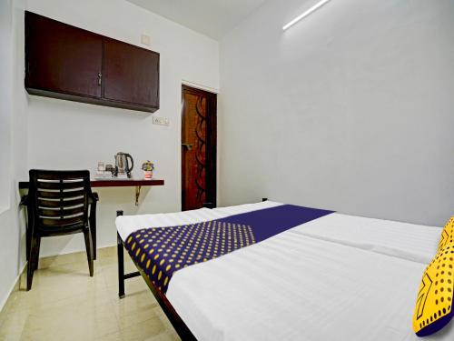 um quarto com uma cama, uma mesa e uma cadeira em Kabas Lodge em Ernakulam