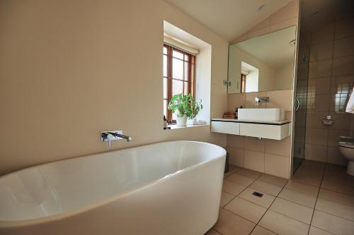 ein Badezimmer mit einer Badewanne, einem Waschbecken und einem WC in der Unterkunft Jacobs Estate Cottage in Rowland Flat
