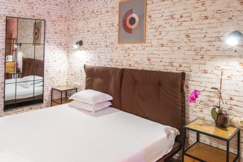 a bedroom with a white bed and a brick wall at Art Hotel Simona in Sofia