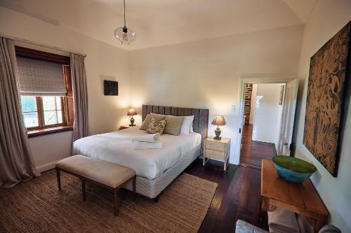 um quarto com uma cama, uma cadeira e uma janela em Jacobs Estate Cottage em Rowland Flat