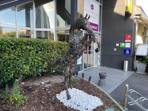 Una statua di drago davanti a un edificio. di Hotel Restaurant Du Parc Saumur Logis Elégance a Saumur