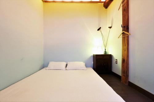 a bedroom with a white bed and a table at NagNe House Boutique Hanok in Seoul