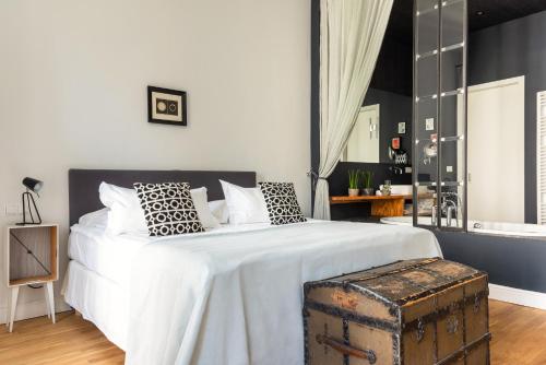a bedroom with a large white bed with a trunk at Gorki Apartments in Berlin