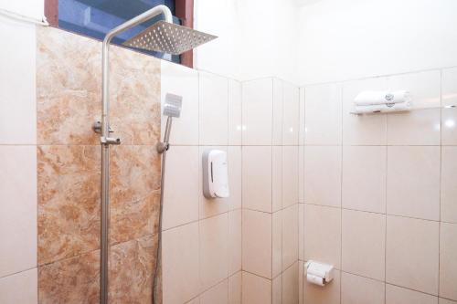 a bathroom with a shower with a glass door at Urbanview Syariah Wisma Wongso Borobudur in Magelang