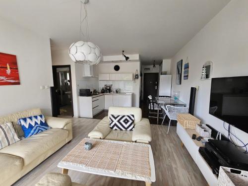 uma sala de estar com um sofá e uma mesa em Stella Baltic big terrace 3 Zimmer frei parking em Świnoujście