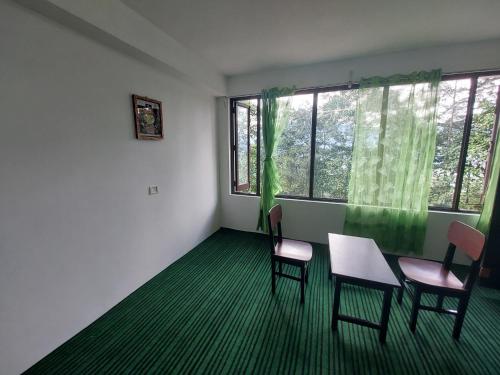 a room with chairs and a table and a window at Norbulingka Retreat in Gyalzing