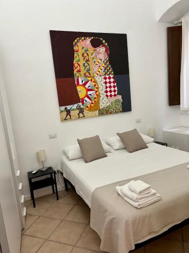 two beds in a room with a painting on the wall at THE PALACE B&B and Apartments in Santo Stefano di Camastra