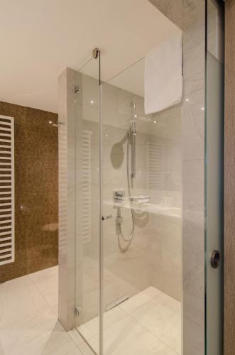 a bathroom with a shower with a glass door at IMLAUER HOTEL PITTER Salzburg in Salzburg