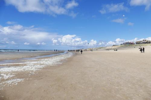 eine Gruppe von Menschen, die am Strand spazieren in der Unterkunft Ammophila 1 in Egmond aan Zee