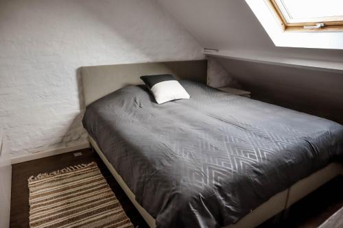 a bed in a small room with a window at L'Abri in Ypres