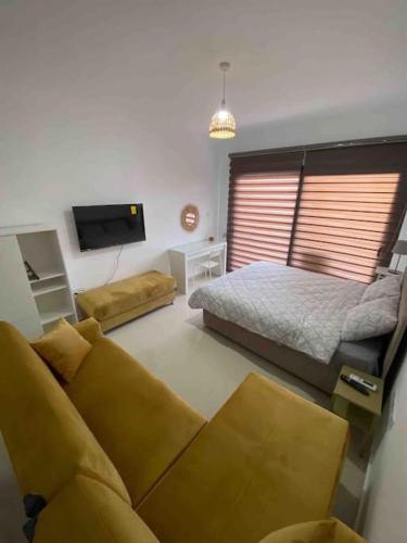 a living room with a bed and a couch at Studio Alev POOLview-CaesarResortSpa(North Cyprus) in Perivolia tou Trikomou