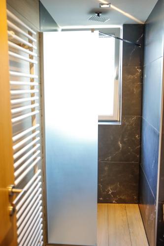 a bathroom with a shower and a glass door at Studio Apartments Visit Point in Sarajevo