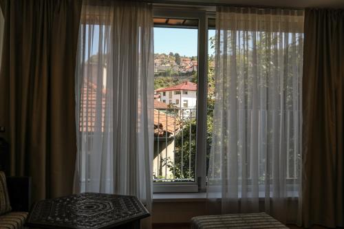 a room with a large window with white curtains at Studio Apartments Visit Point in Sarajevo