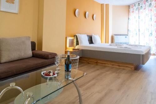 a room with a bed and a couch and a table at Art Hotel Simona in Sofia