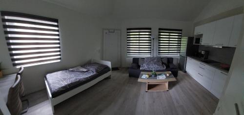 a living room with a bed and a table and windows at Ferienwohnung am Stadtwald in Freiberg
