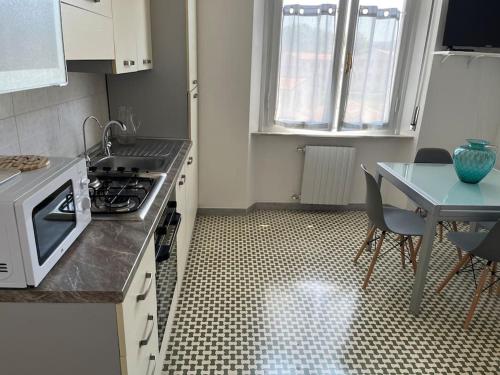 a kitchen with a stove top oven next to a table at Il Pesce di Legno in Livorno