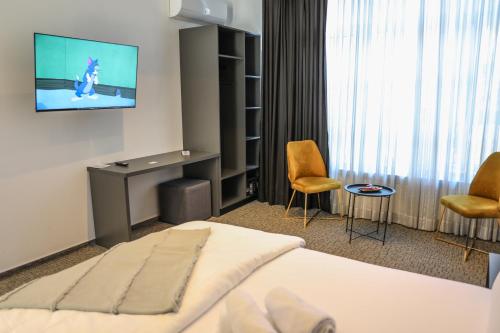a hotel room with a bed and a flat screen tv at Studio Apartments Visit Point in Sarajevo