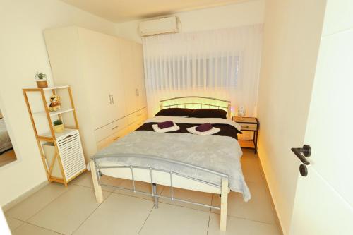 Habitación pequeña con cama y mesita de noche en הטרקלין של שלמה. דירה יפה וחדשה 5 דקות נסיעה מהים en Ashkelon