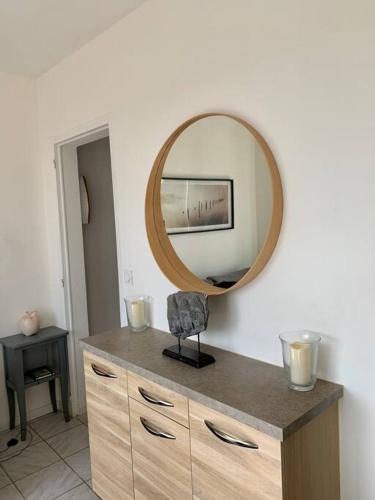 un miroir au-dessus d'une commode dans une pièce dans l'établissement Le Duna, à Soorts-Hossegor