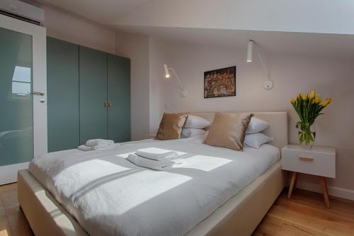 1 dormitorio con 1 cama blanca grande y armarios verdes en Tyzenhauz Apartments Dietla Street, en Cracovia