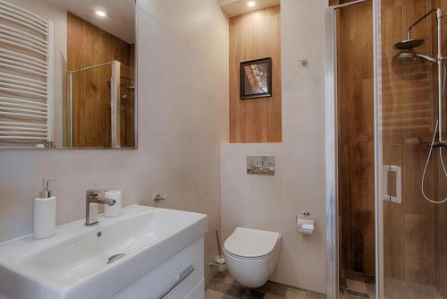 y baño con aseo, lavabo y ducha. en Tyzenhauz Apartments Dietla Street, en Cracovia