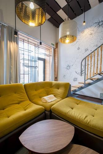 a living room with a yellow couch and a table at Inn OZZ in Karagandy