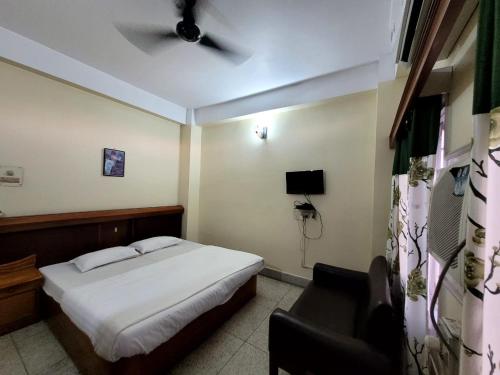 Hotel Tawang Inn في تاوانج: غرفة نوم فيها سرير وكرسي