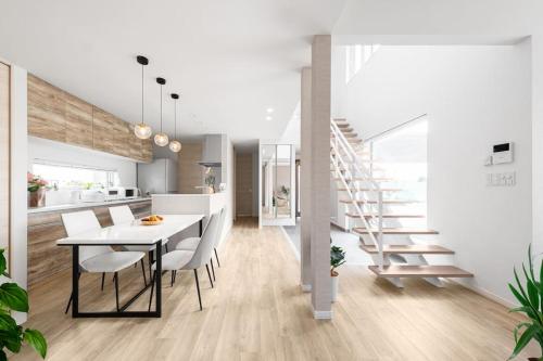 a kitchen and dining room with a table and a staircase at THE Prestige in Asahikawa