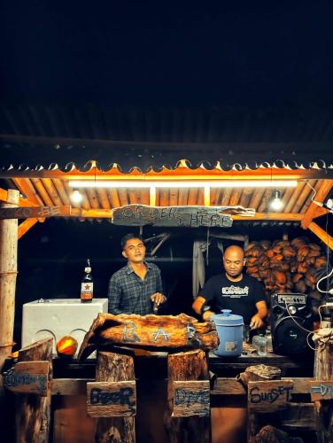 two men standing in a kitchen with some food at Sirus Base Camp Tagulandang in Kisihang