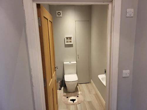 a bathroom with a toilet with a stuffed animal on the floor at 3 bedroom spacious house with parking in Northwood