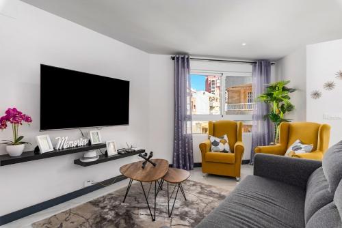 salon z kanapą i telewizorem na ścianie w obiekcie Apartamento Baltico, 50m to Los Locos Beach w mieście Torrevieja