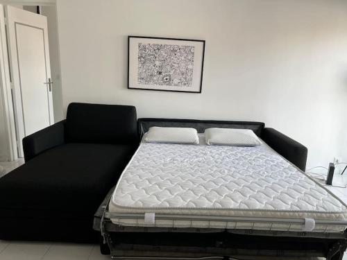 a bed in a room with a black bed frame at Luminous appartment in Paris with balcony in Aubervilliers