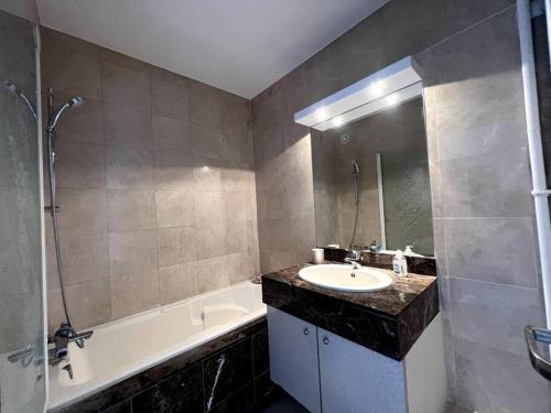 y baño con lavamanos, bañera y lavamanos. en Luminous appartment in Paris with balcony en Aubervilliers
