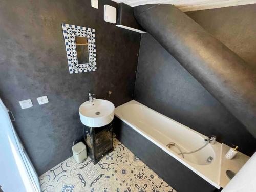 a bathroom with a bath tub and a sink at La tiny house de Chaparon in Lathuile