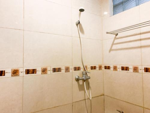 y baño con ducha con cabezal de ducha. en Musafira Hotel Syariah Malioboro Yogyakarta Mitra RedDoorz, en Yogyakarta