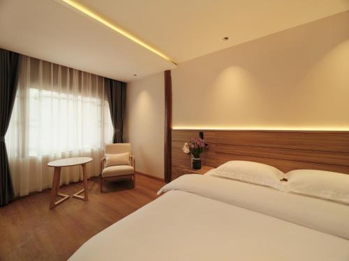 Habitación de hotel con cama y silla en XILU INN muxin, en Lijiang